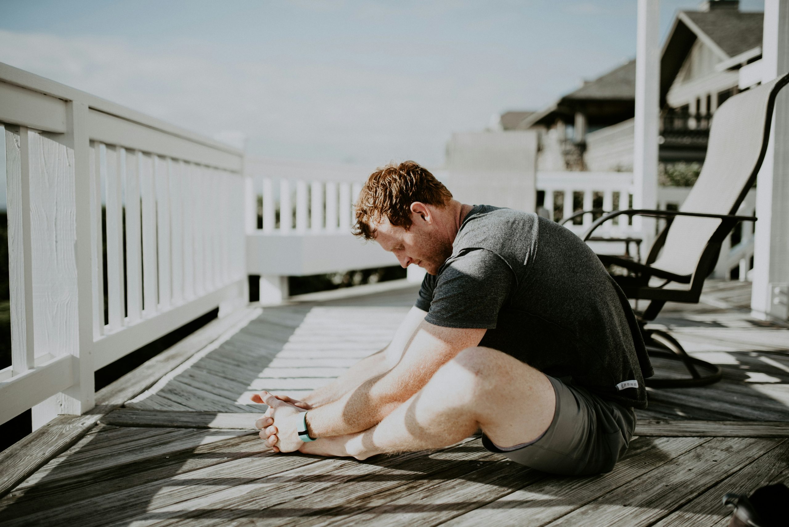 Person performing a seated back stretch — one of the recommended physiotherapy exercises for lower back pain