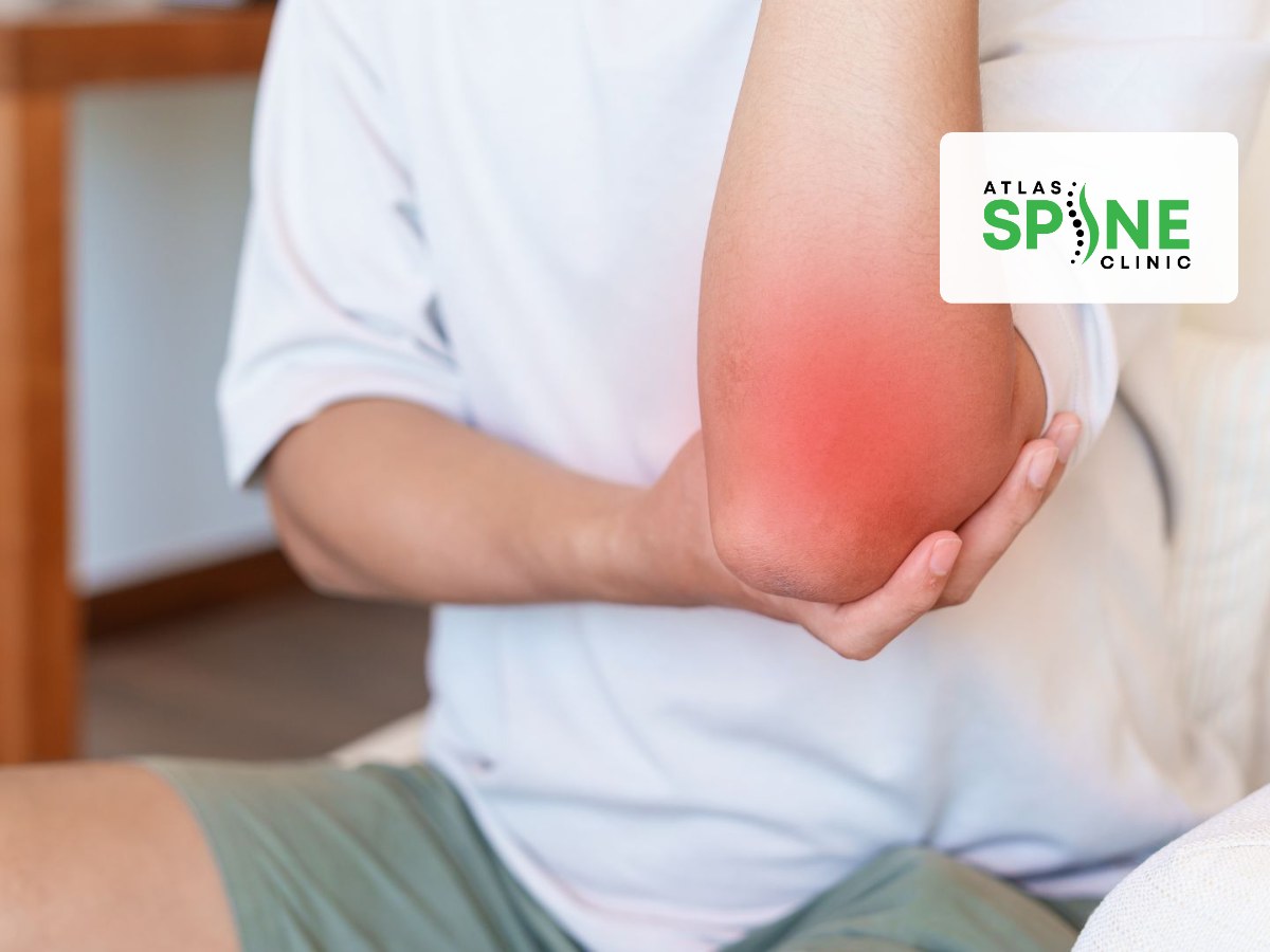 Person at home holding a sore elbow with a red glow, showing everyday elbow pain from repetitive strain