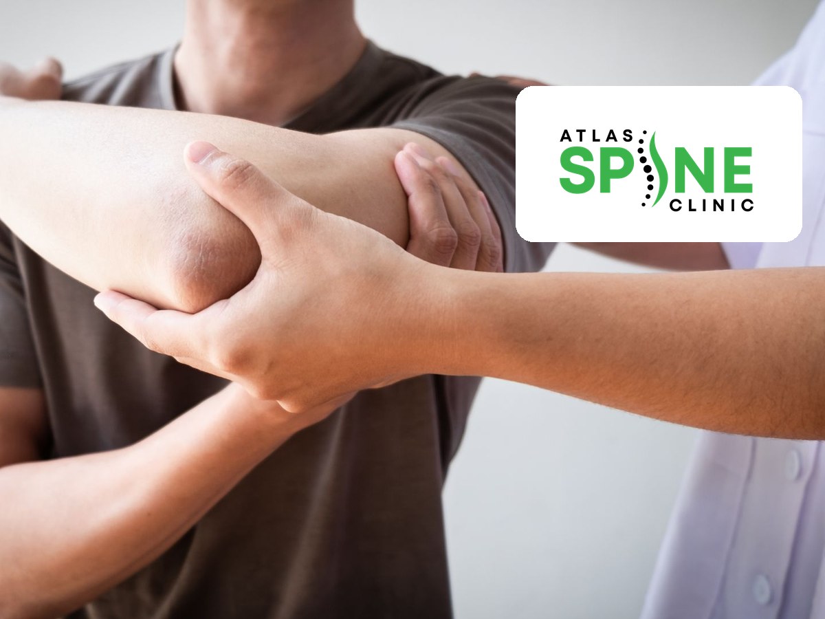 Clinician assessing a patient's shoulder movement at Atlas Spine Clinic in Scarborough