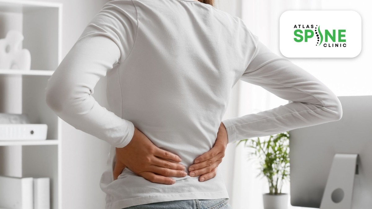 Woman holding her lower back and sacroiliac area while standing