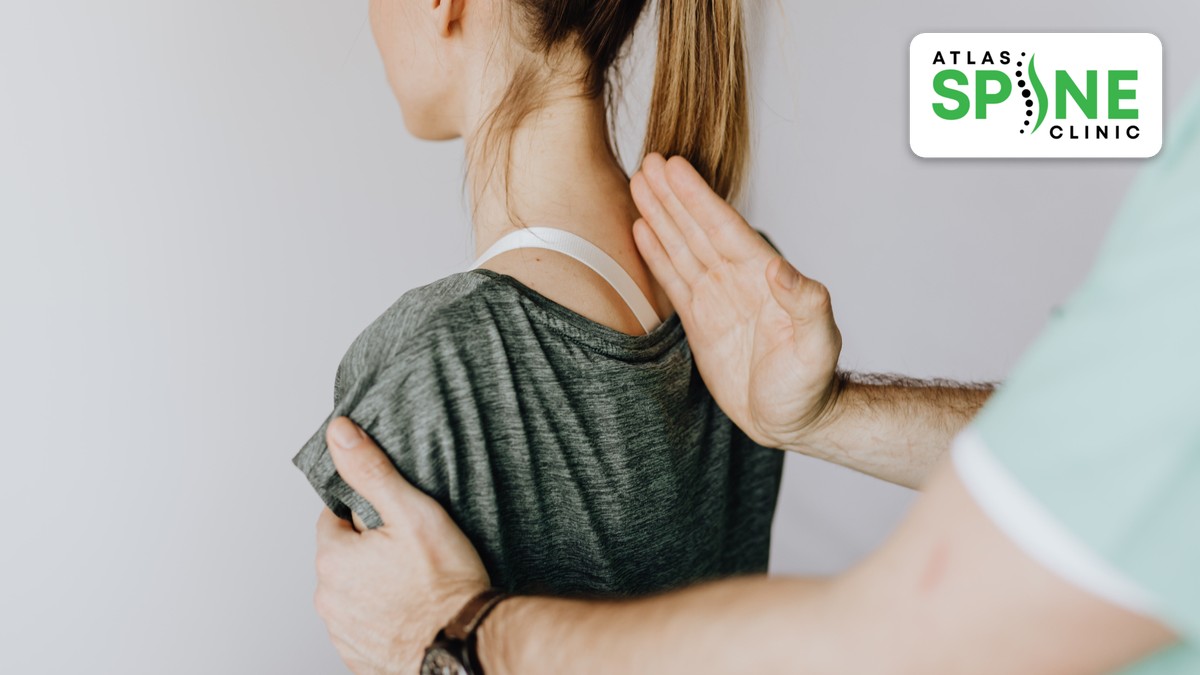 Practitioner assessing a patient's upper back and spine at Atlas Spine Clinic in Scarborough