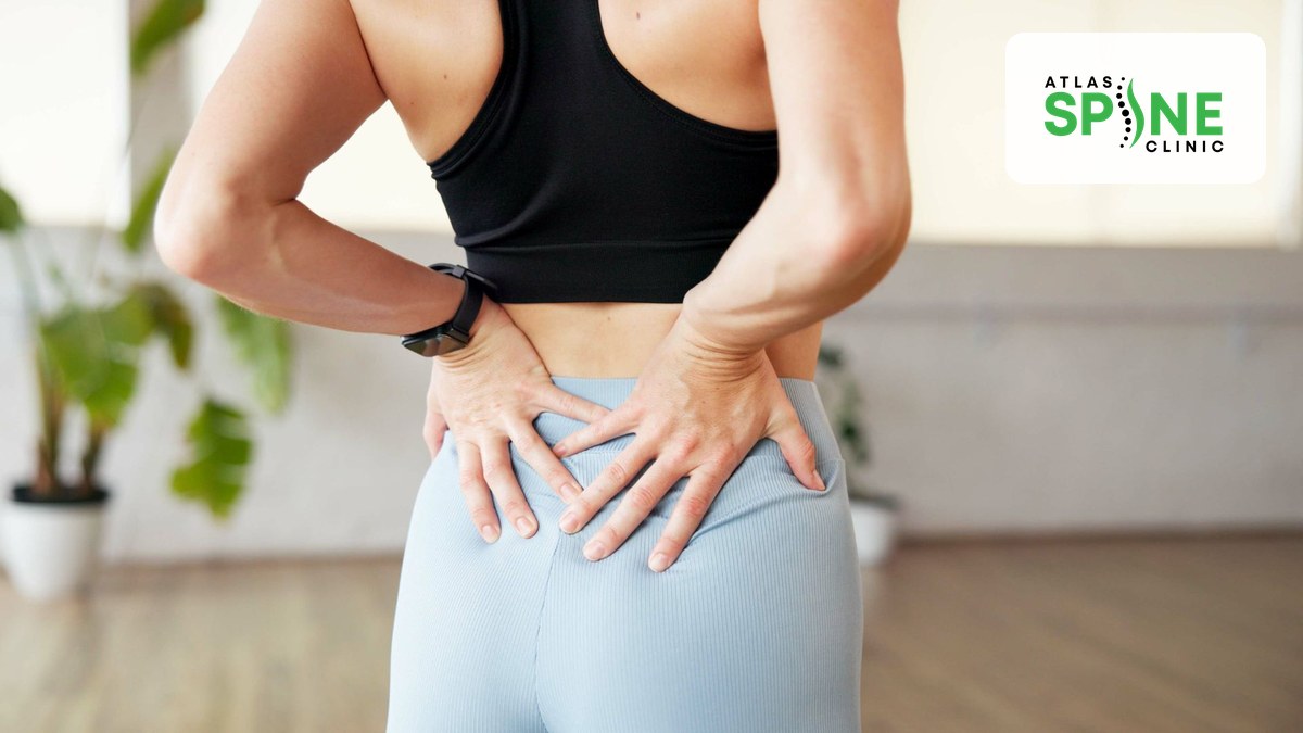 Person holding their lower back and hip from disc-related back pain at Atlas Spine Clinic in Scarborough