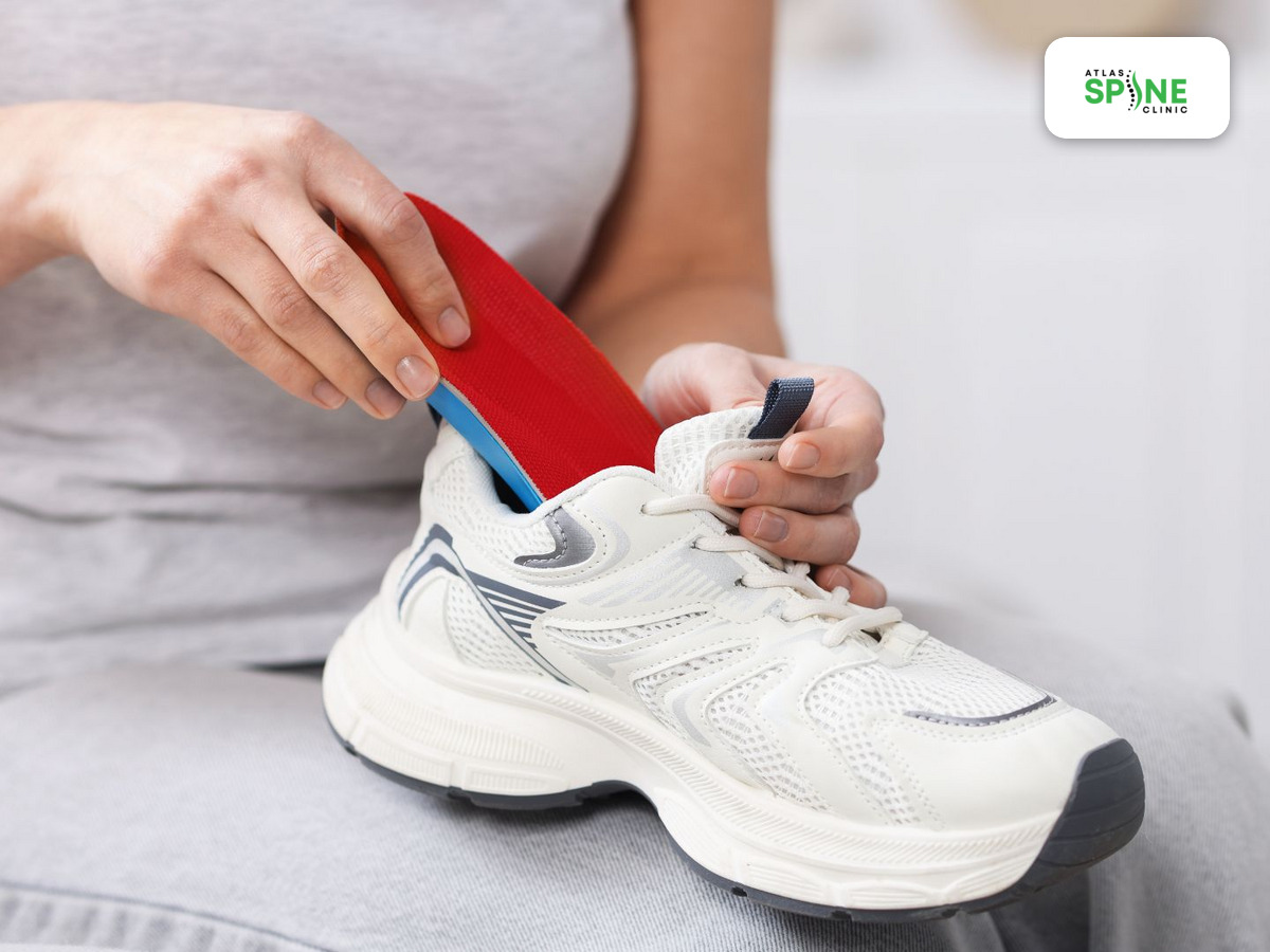 Placing a custom orthotic into a running shoe at Atlas Spine Clinic in Scarborough