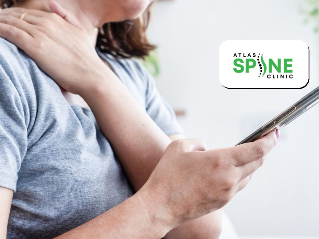 Person holding a phone and rubbing a sore neck, a sign of text neck